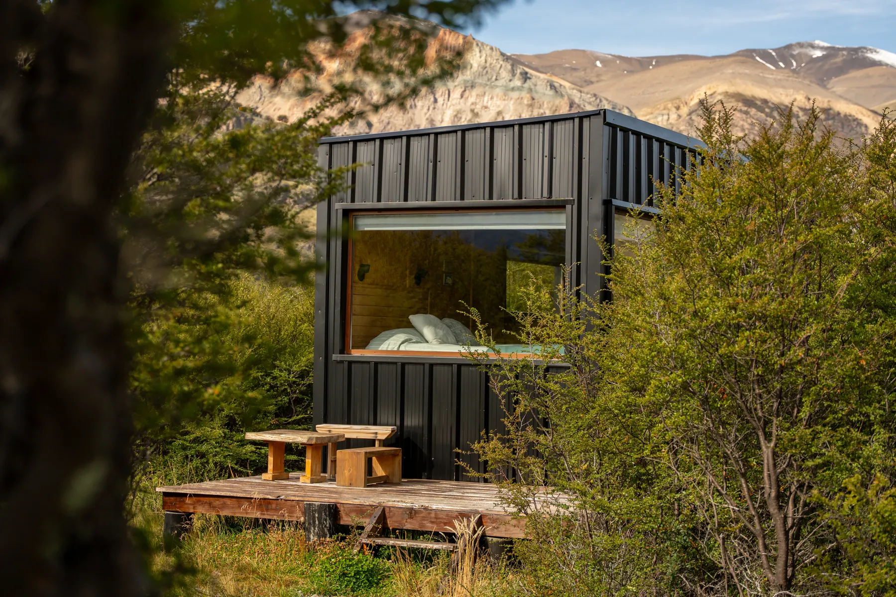 Una de las casas con su deck, entre el bosque y la montaña